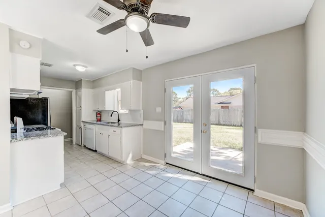 a large white kitchen with cabinets a sink a stove and a refrigerator