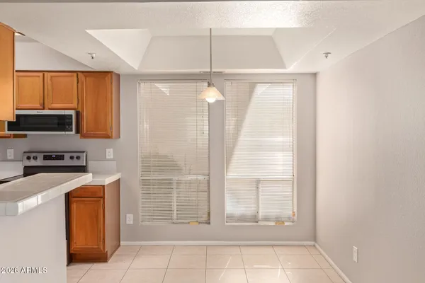 a view of kitchen with granite countertop cabinets and refrigerator