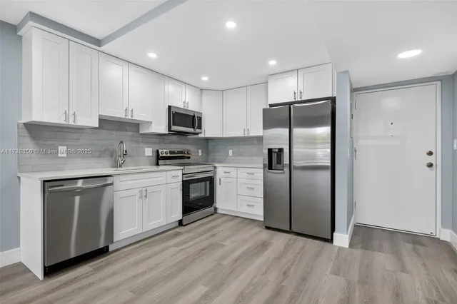 a kitchen with granite countertop a stove a sink and a microwave