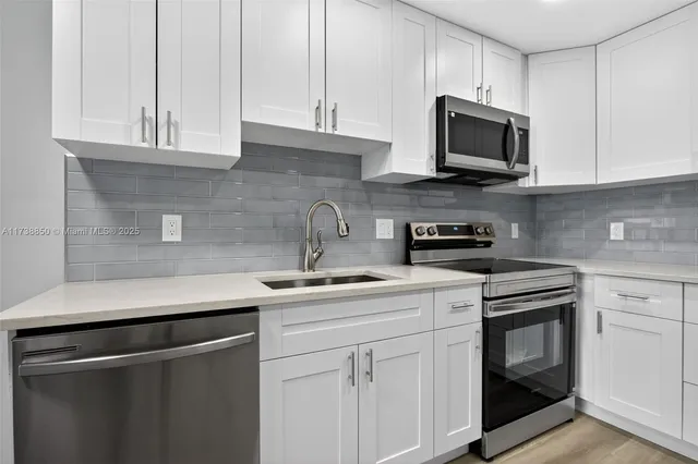 a kitchen with stainless steel appliances granite countertop a stove a sink and a microwave