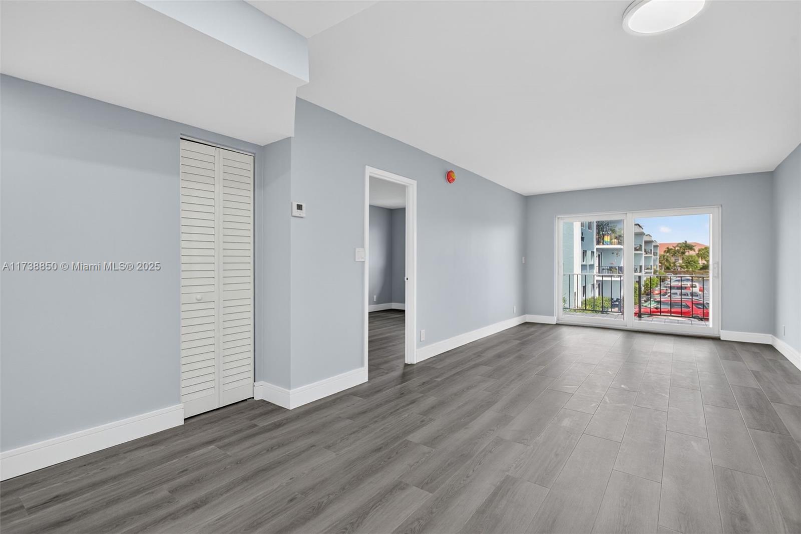 3004 Northeast 5th Terrace, Unit 214C Wilton Manors, FL 33334 - Photo 26 of 99 an empty room with wooden floor and windows