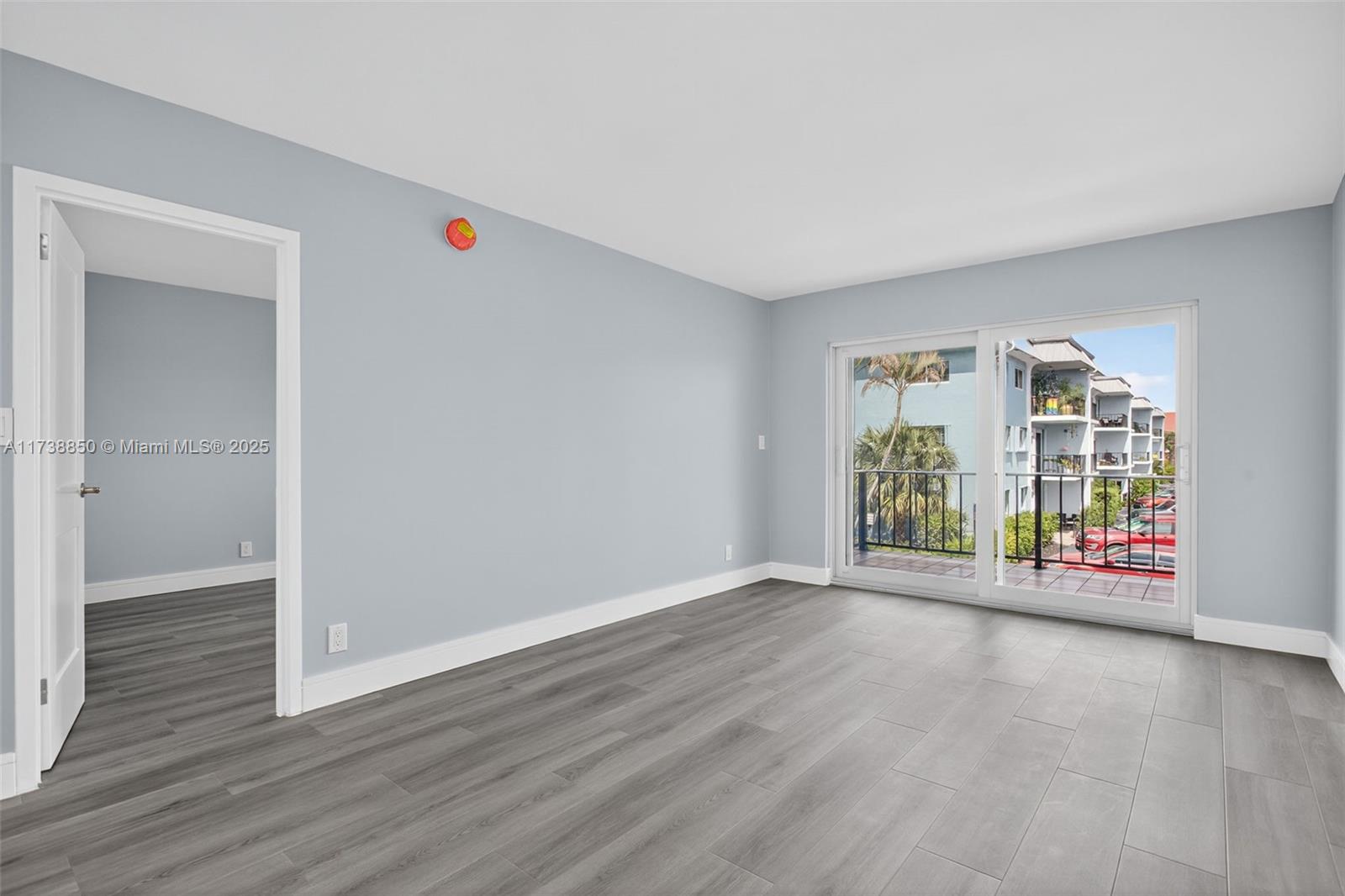 3004 Northeast 5th Terrace, Unit 214C Wilton Manors, FL 33334 - Photo 28 of 99 an empty room with wooden floor and windows