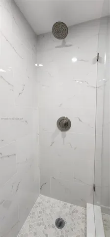 a view of a house with large windows and plants