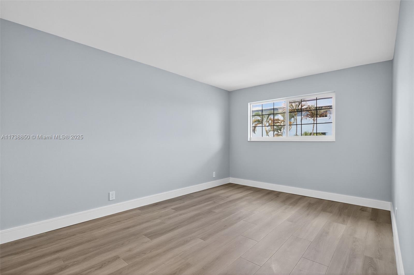 3004 Northeast 5th Terrace, Unit 214C Wilton Manors, FL 33334 - Photo 39 of 99 a view of an empty room with wooden floor and a window