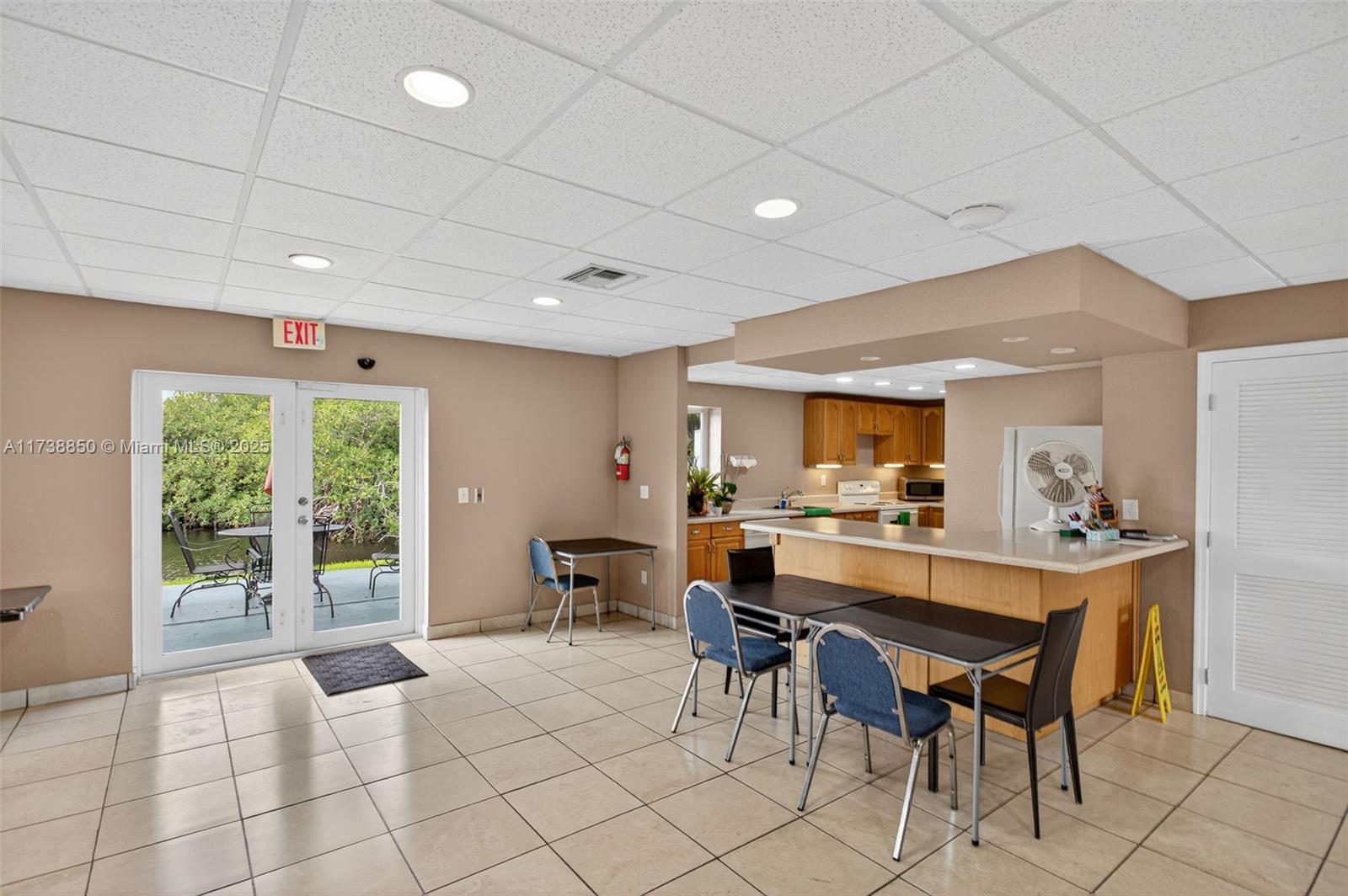 3004 Northeast 5th Terrace, Unit 214C Wilton Manors, FL 33334 - Photo 56 of 99 a kitchen with a table and chairs in it