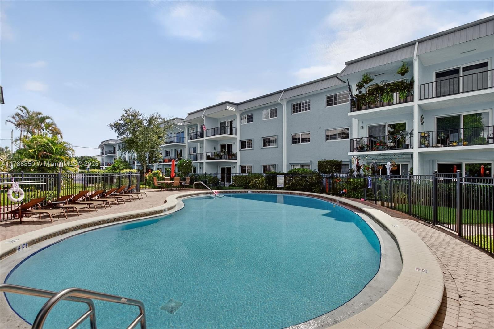 3004 Northeast 5th Terrace, Unit 214C Wilton Manors, FL 33334 - Photo 57 of 99 a swimming pool with outdoor seating and yard