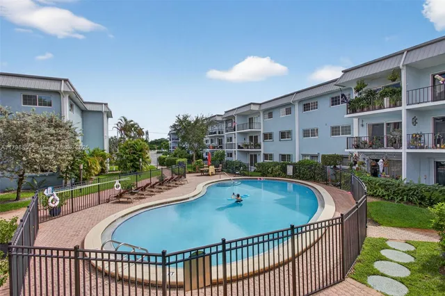 an aerial view of a house with a swimming pool and outdoor seating