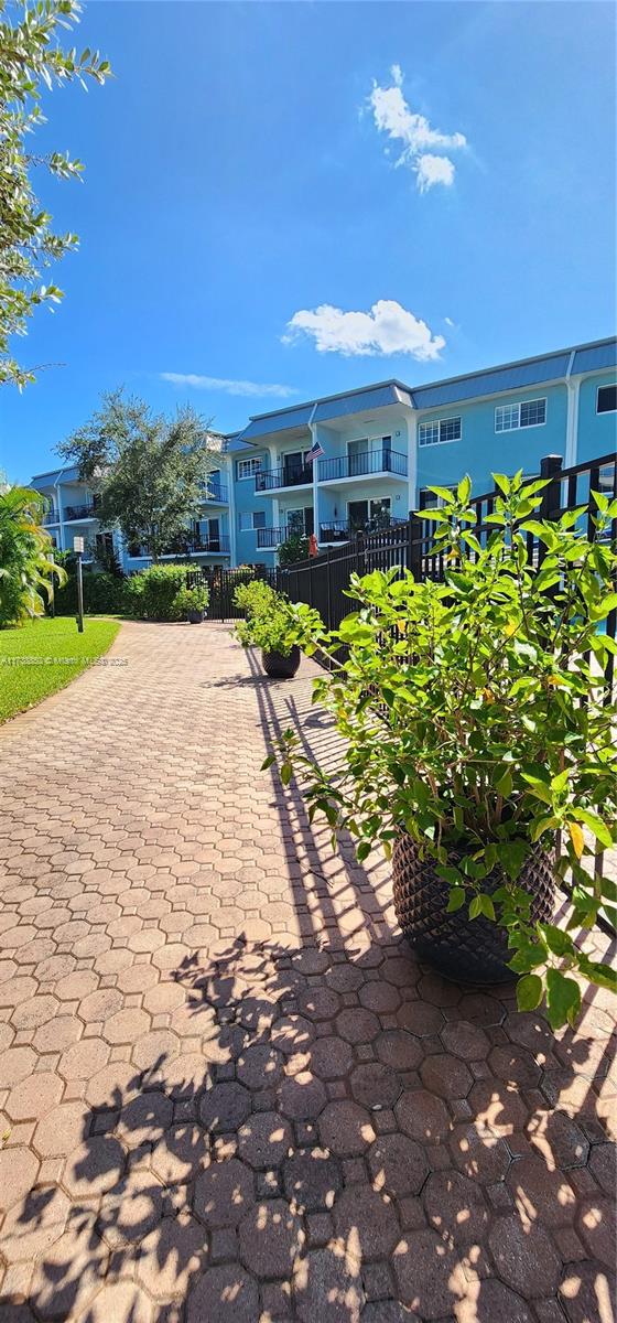 3004 Northeast 5th Terrace, Unit 214C Wilton Manors, FL 33334 - Photo 62 of 99 a view of a patio with table and chairs under an umbrella