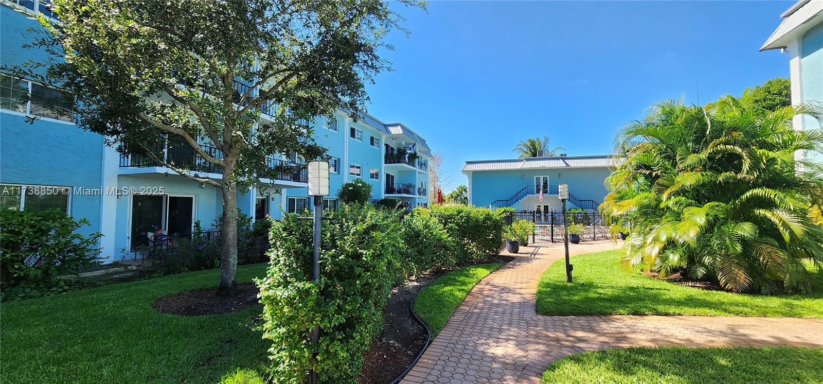 3004 Northeast 5th Terrace, Unit 214C Wilton Manors, FL 33334 - Photo 7 of 99 a front view of a house with a yard and potted plants