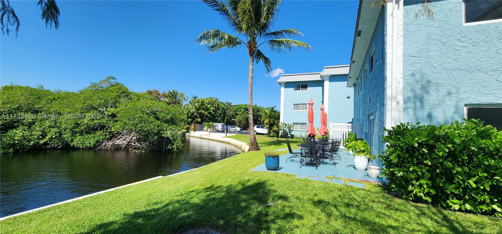 3004 Northeast 5th Terrace, Unit 214C Wilton Manors, FL 33334 - Photo 72 of 99 a view of a chair and table in the patio with a lake view