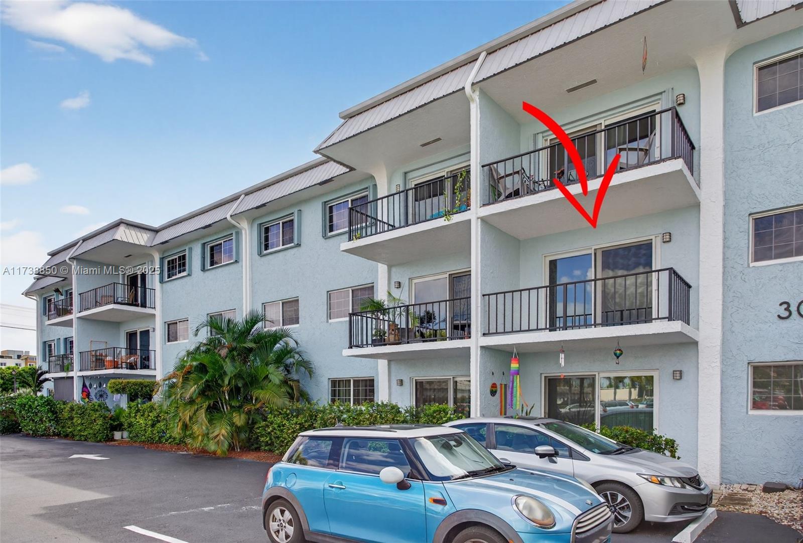 3004 Northeast 5th Terrace, Unit 214C Wilton Manors, FL 33334 - Photo 9 of 99 a front view of a residential apartment building with a yard