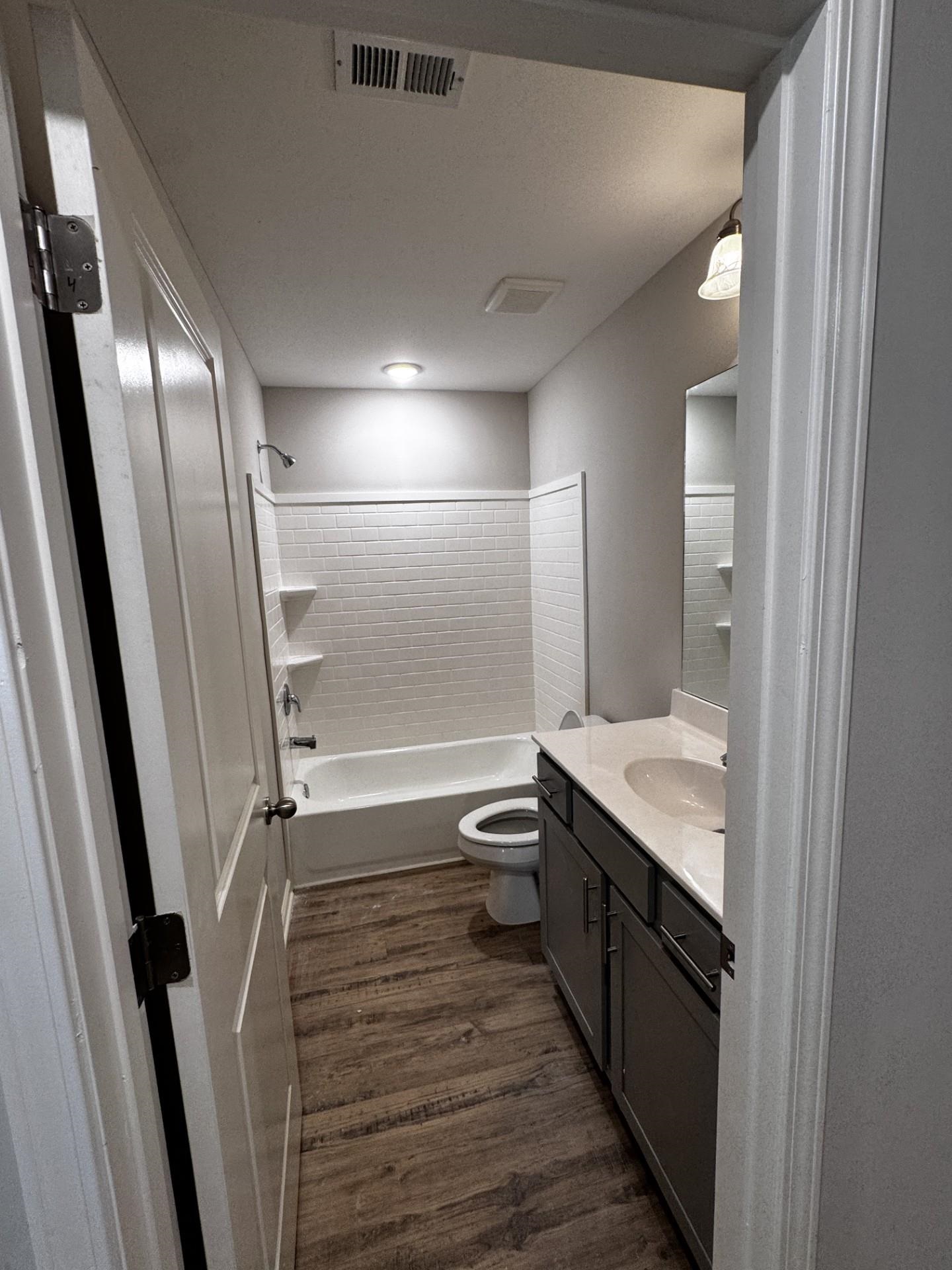 5263 Zodiac Road Memphis, TN 38118 - Photo 6 of 9 Bathroom with vanity, shower / tub combination, and dark wood-style floors