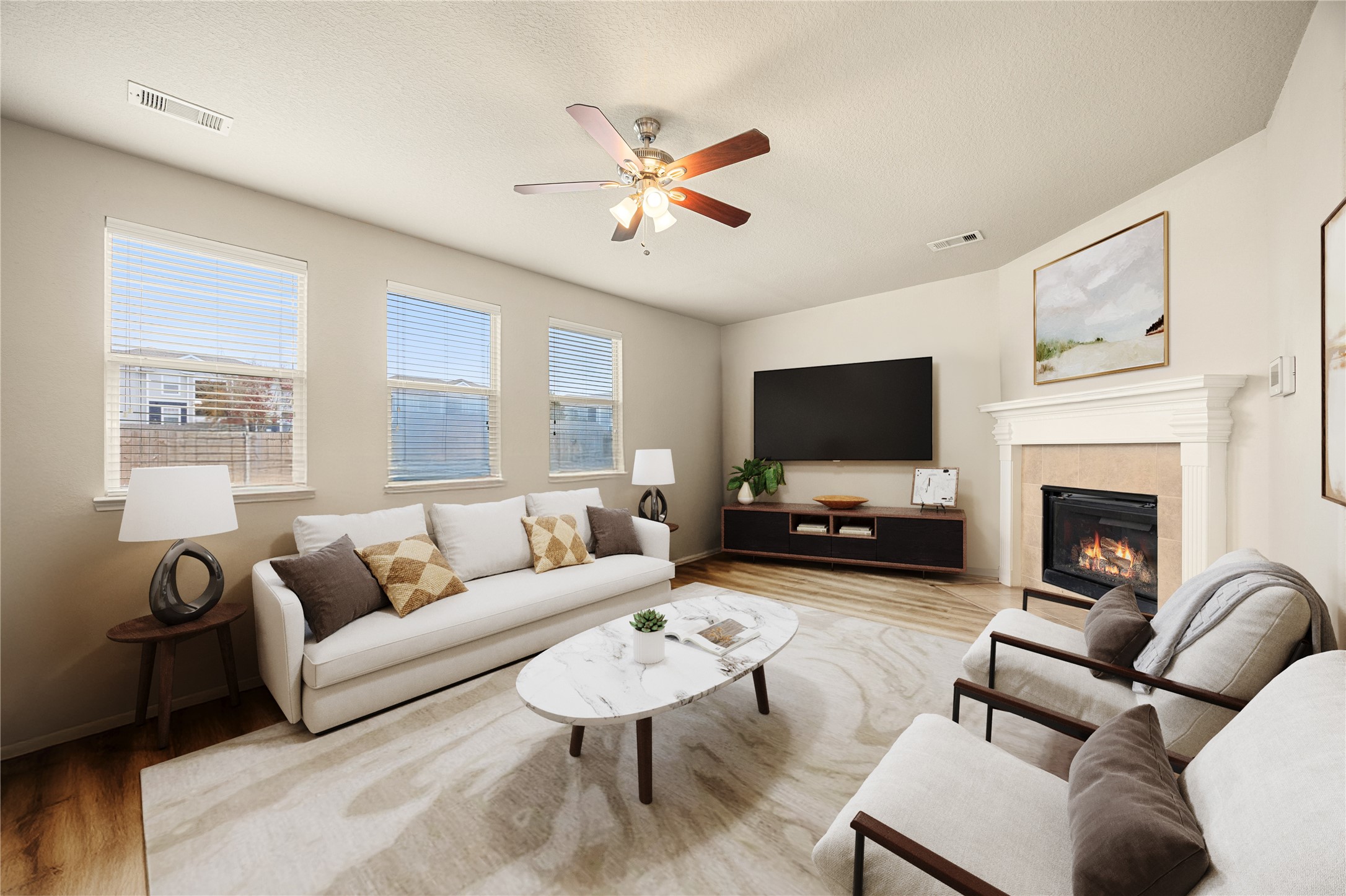 3526 Canvasback Lane Houston, TX 77047 - Photo 7 of 22 This living room feels more like a great room, featuring a beautiful fireplace with classic mantel detailing, neutral paint tones, soaring ceilings, a dark-stained ceiling fan with light fixture, and multiple windows that fill the space with natural light, creating a bright and welcoming area for relaxing or entertaining. *Virtually Staged
