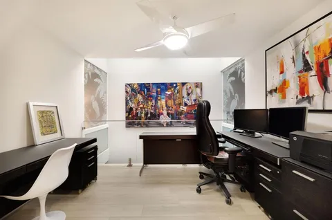 a view of a workspace with furniture and a window