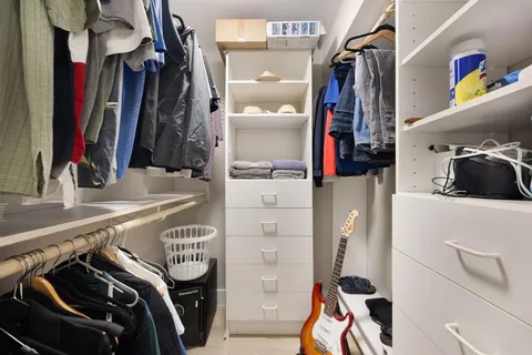 a view of walk in closet with clothes and shoes