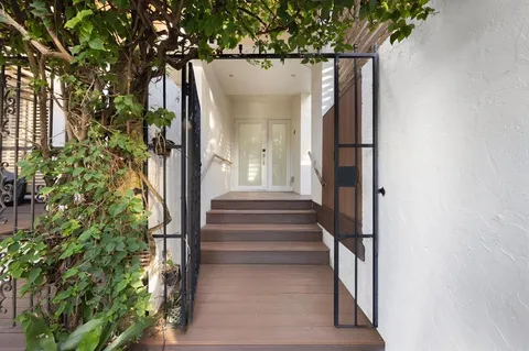 a kitchen view white cabinets and a wooden floor