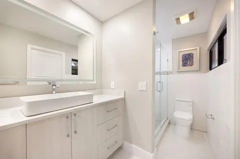 a bathroom with a sink a toilet and a mirror