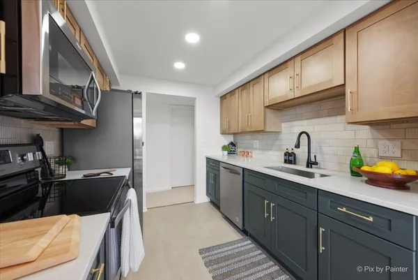 a kitchen with stainless steel appliances a sink dishwasher stove refrigerator and cabinets