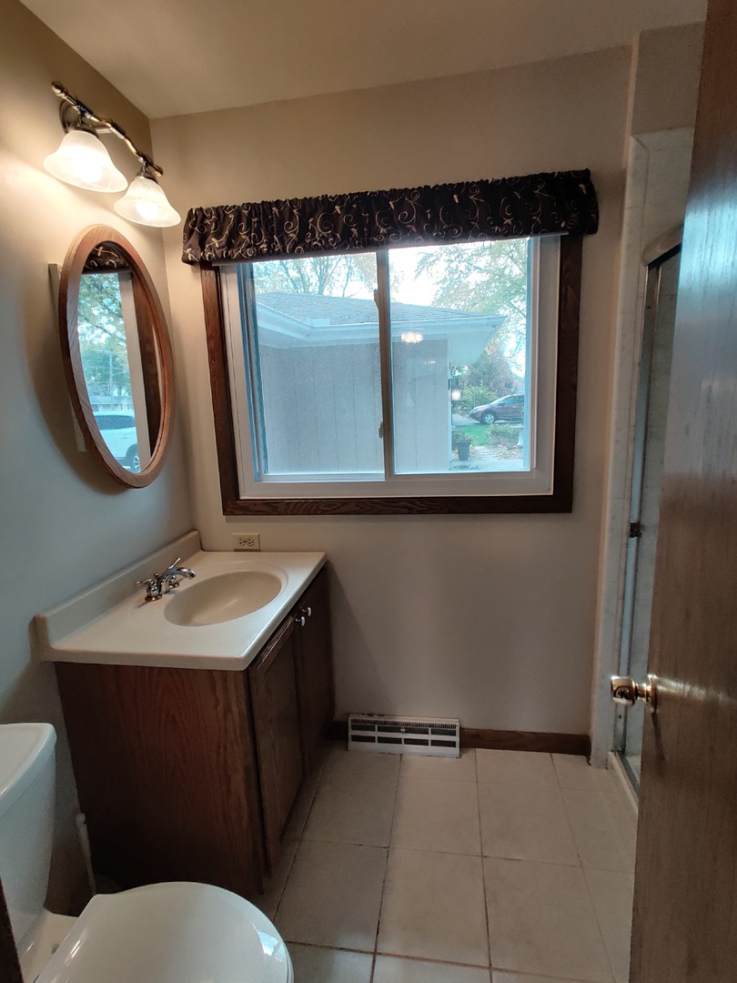 8N601 Stevens Road Elgin, IL 60124 - Photo 16 of 34 a bathroom with a toilet sink vanity and mirror