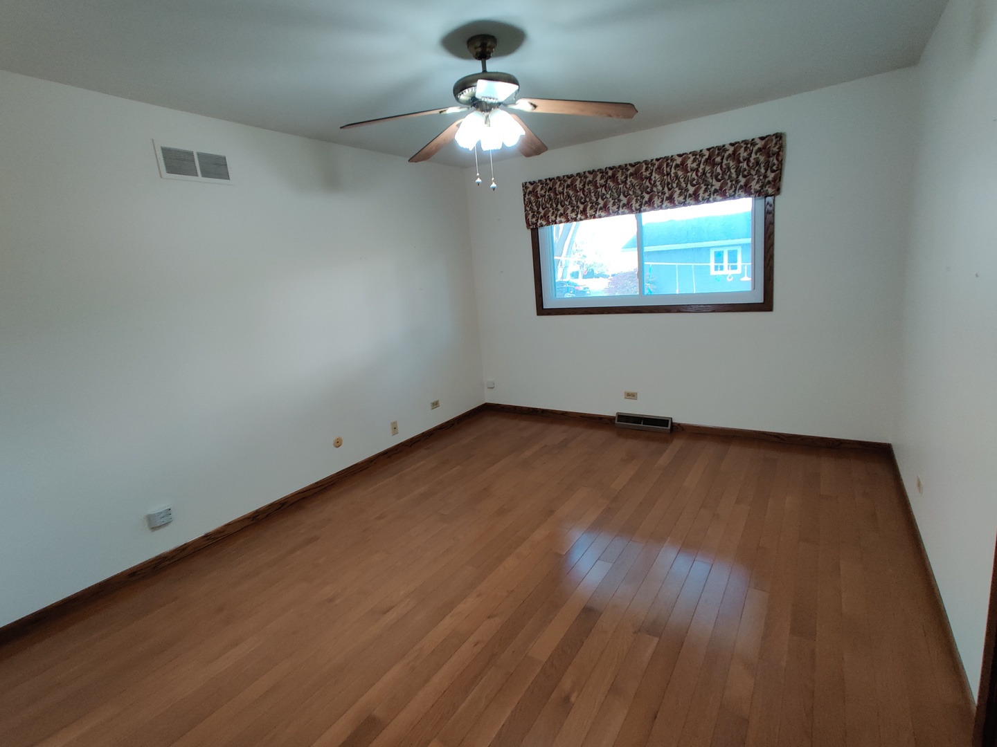 8N601 Stevens Road Elgin, IL 60124 - Photo 22 of 34 an empty room with wooden floor chandelier fan and windows