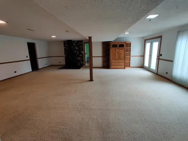 a view of an empty room with closet and a window