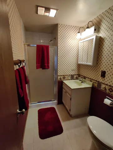 a bathroom with a granite countertop sink mirror vanity and toilet