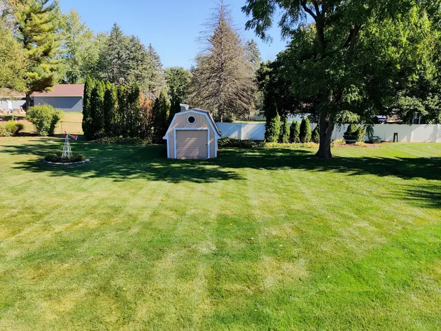 a front view of a house with garden and trees