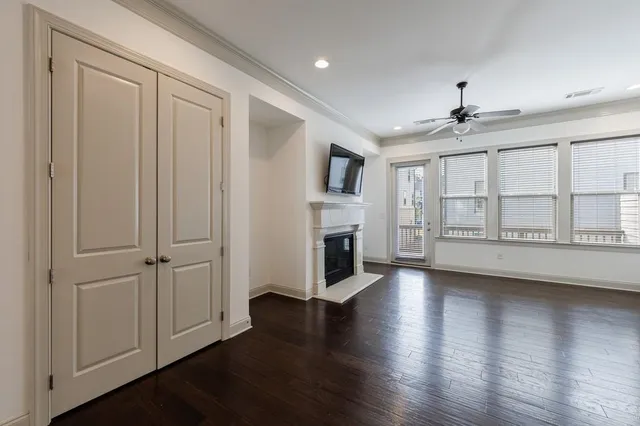 an empty room with wooden floor fireplace and windows