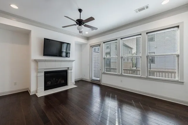a view of wooden floor fire place and windows in a room