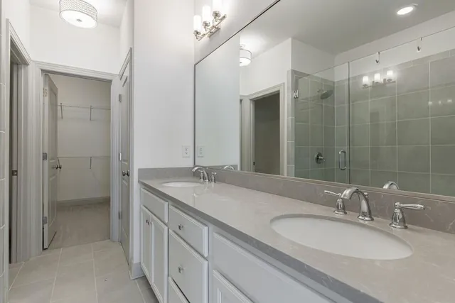 a bathroom with a granite countertop sink double and mirror