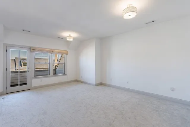 an empty room with furniture and windows