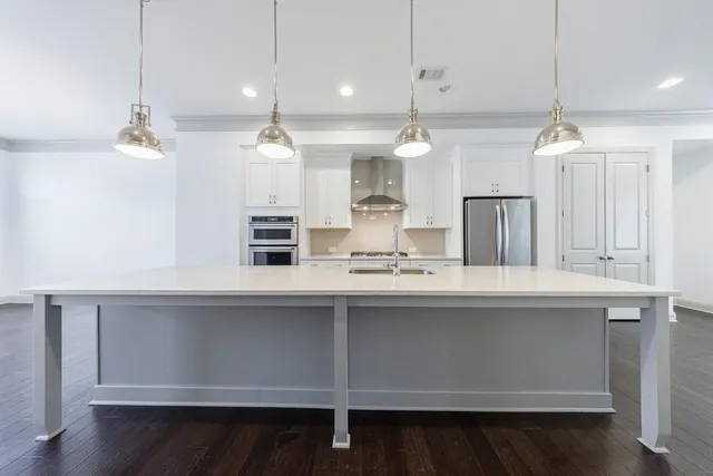 a kitchen with kitchen island sink stove and cabinets
