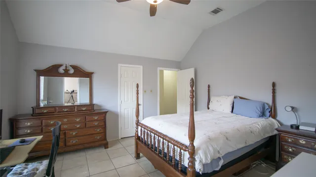 a bedroom with a bed a dresser and potted plants