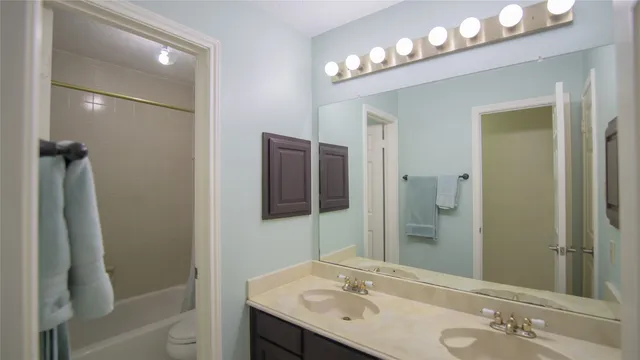 a bathroom with a sink tub and a mirror