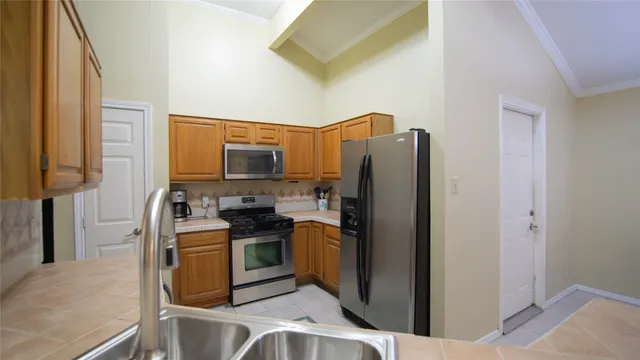 a kitchen with stainless steel appliances granite countertop a refrigerator and a stove top oven