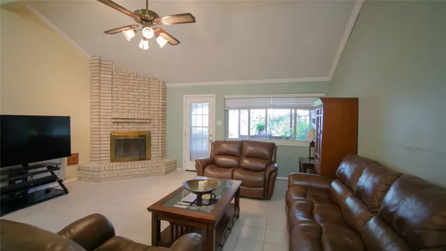 a living room with furniture a flat screen tv and a fireplace