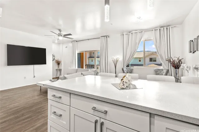 a living room with furniture kitchen view and a chandelier