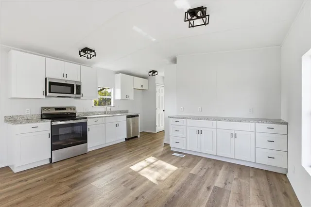 a kitchen with granite countertop white cabinets and white appliances