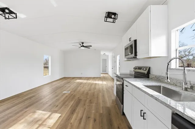 a kitchen with a sink cabinets and wooden floor