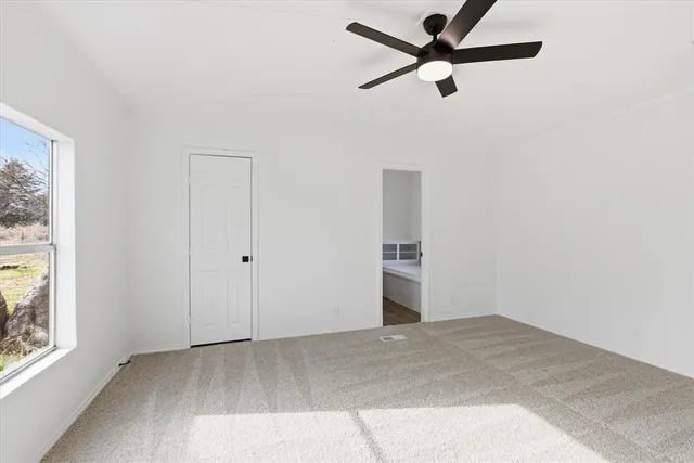 a view of a room with a ceiling fan and a window