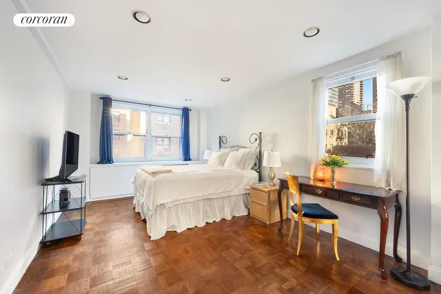 a bedroom with a bed and a flat tv screen on the dresser