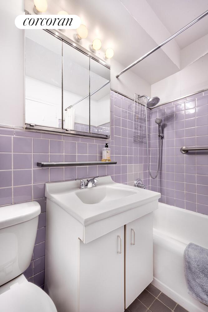 315 East 70th Street, Unit 4D Manhattan, NY 10021 - Photo 6 of 6 a bathroom with a sink toilet vanity and tub