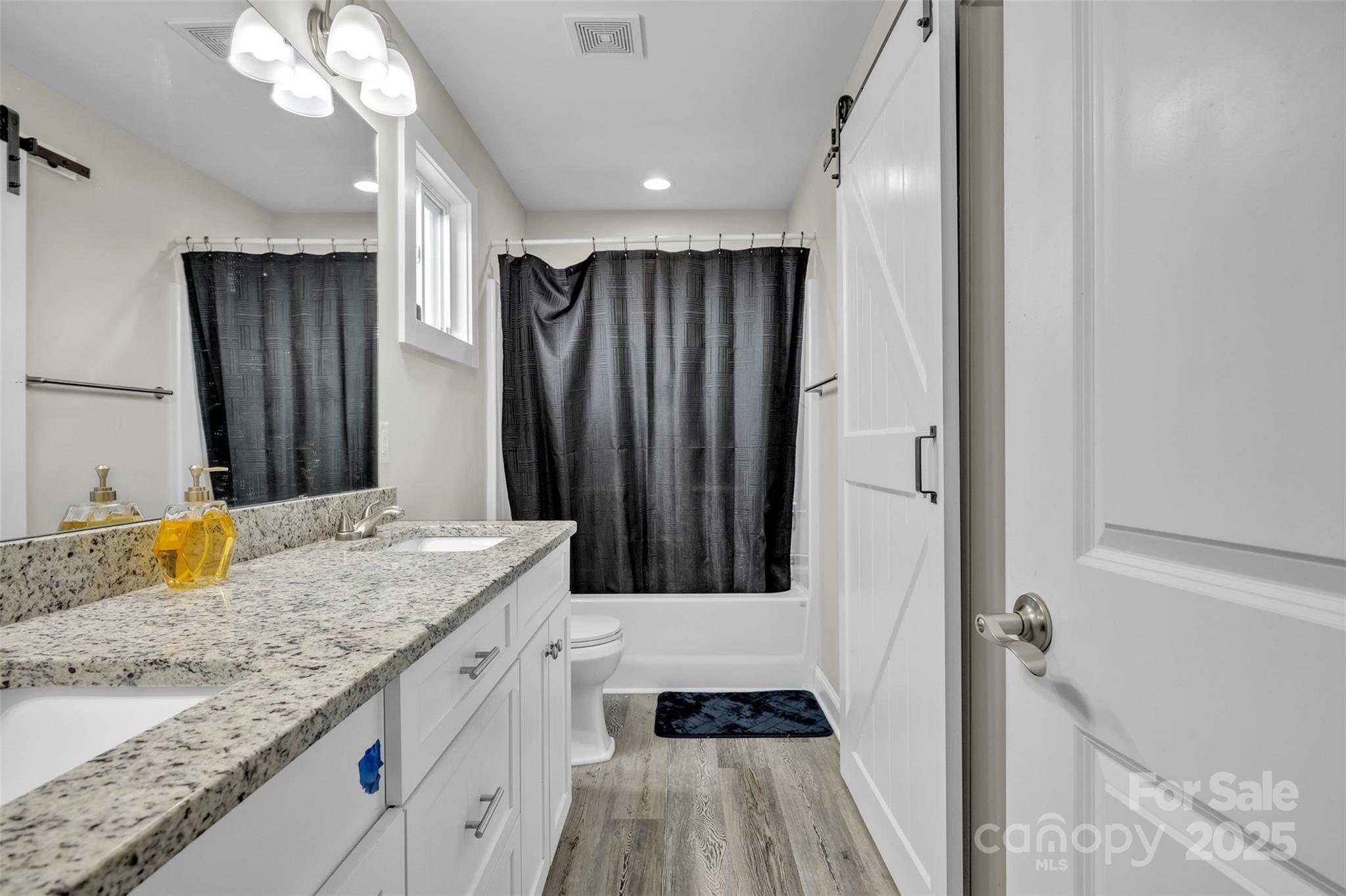 2510 Snow Creek Road Northeast Hickory, NC 28601 - Photo 32 of 45 a bathroom with a granite countertop sink a toilet a mirror and shower