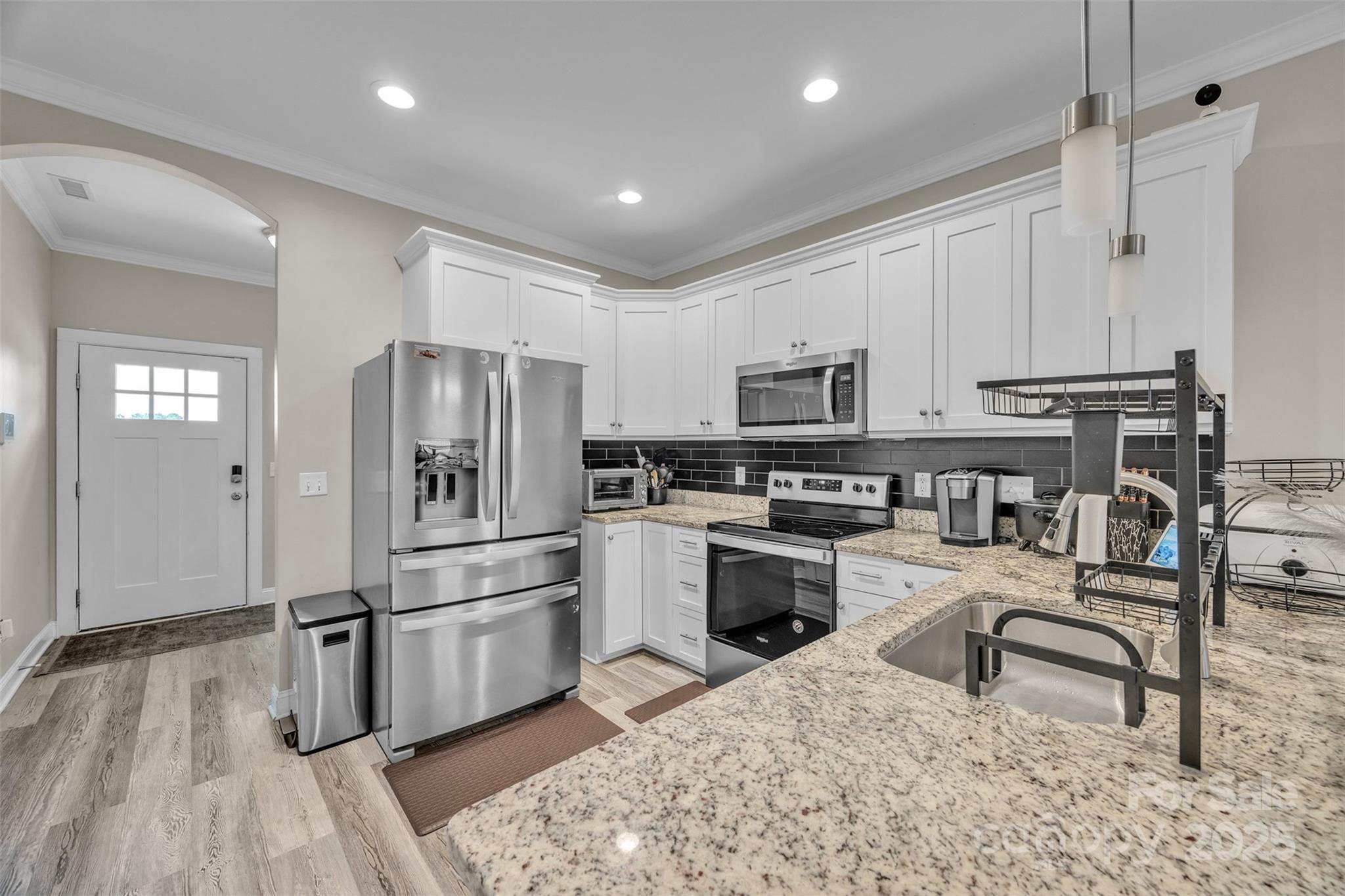 2510 Snow Creek Road Northeast Hickory, NC 28601 - Photo 7 of 45 a kitchen with granite countertop a refrigerator a sink dishwasher a stove and white cabinets with wooden floor