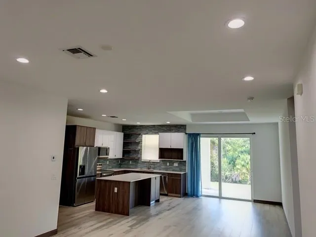 a open kitchen with stainless steel appliances granite countertop a stove and a refrigerator