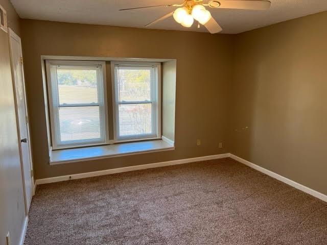 4795 Winchester Road Memphis, TN 38118 - Photo 3 of 7 Carpeted room featuring a double window with a built-in sill, a ceiling fan with integrated lighting, and neutral-toned walls