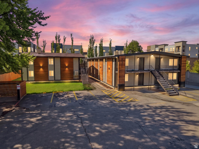 View of front of home with uncovered parking and a lawn