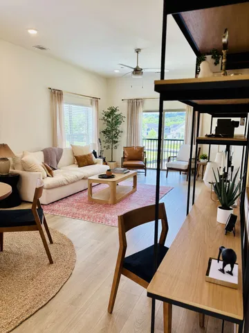 a living room with furniture and a floor to ceiling window