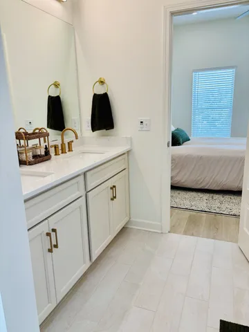 a en suite bathroom with a granite countertop sink and a mirror