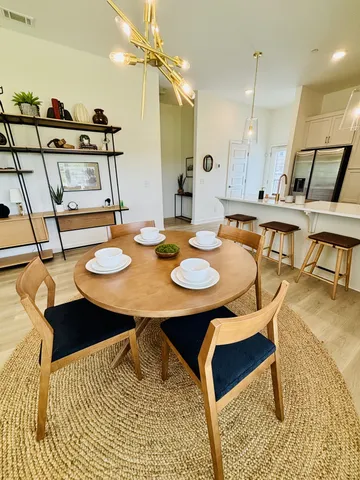 a kitchen with a table chairs and white cabinets